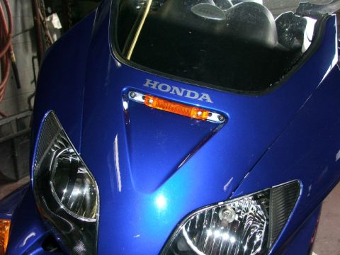 2006 Honda Reflex - Close-up of the front of a blue scooter, showing the headlights and HONDA emblem.