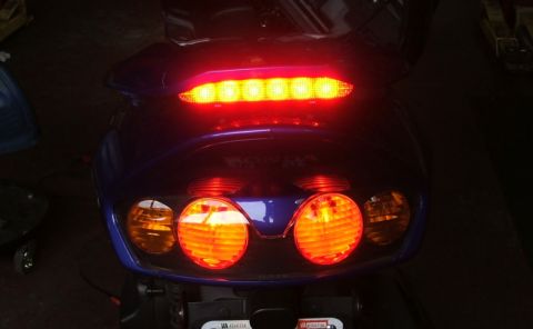 2006 Honda Reflex - Scooter tail lights illuminated, showing brake light and turn signals.