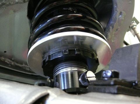 Close-up of adjustable coilover shock absorber with black spring and silver adjustment collar