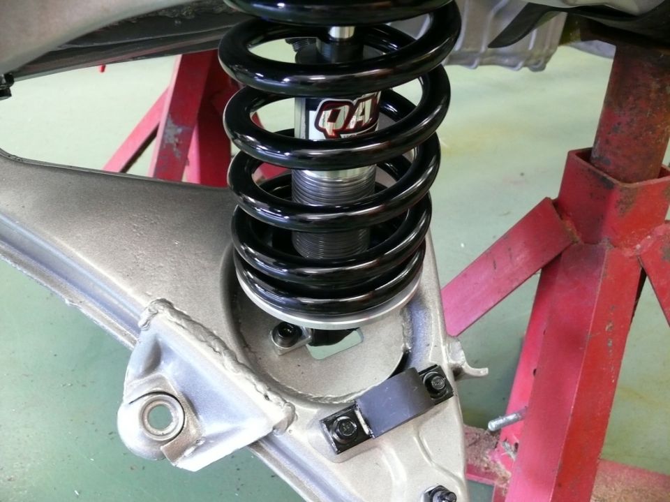 QA1 shock absorber with black coilover spring attached to silver suspension arm