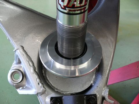 Close-up of a suspension component with a coilover shock absorber. Text on the shock reads 'QA1 SUSPENSION'