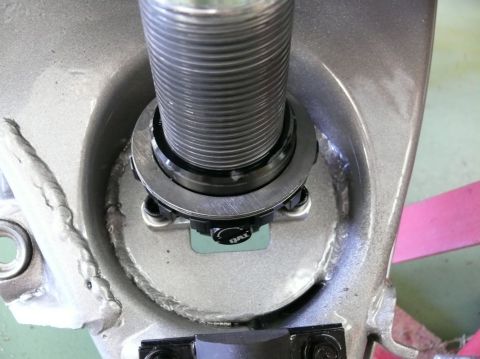 Close-up of a QAI branded suspension part with threaded shaft