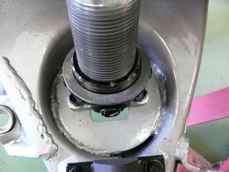 Close-up of a QAI branded suspension part with threaded shaft