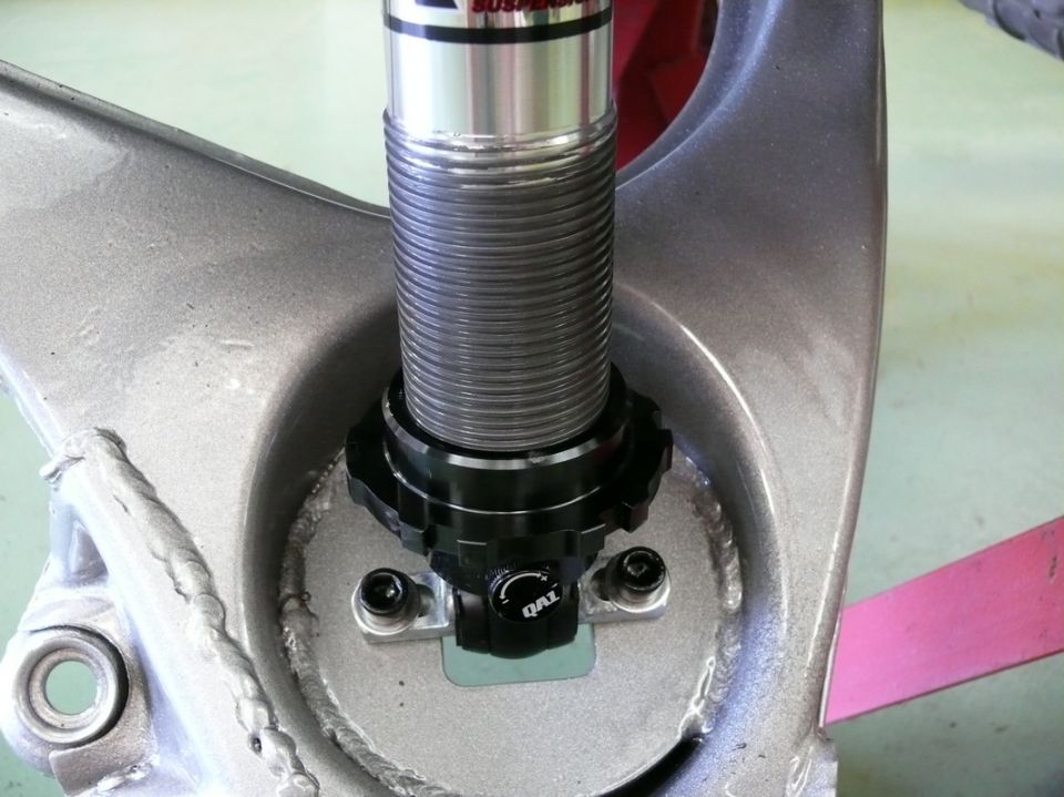 Close-up of a coilover shock absorber with a QAL adjustment knob