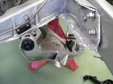 Close-up of a car's suspension and frame parts on jack stands