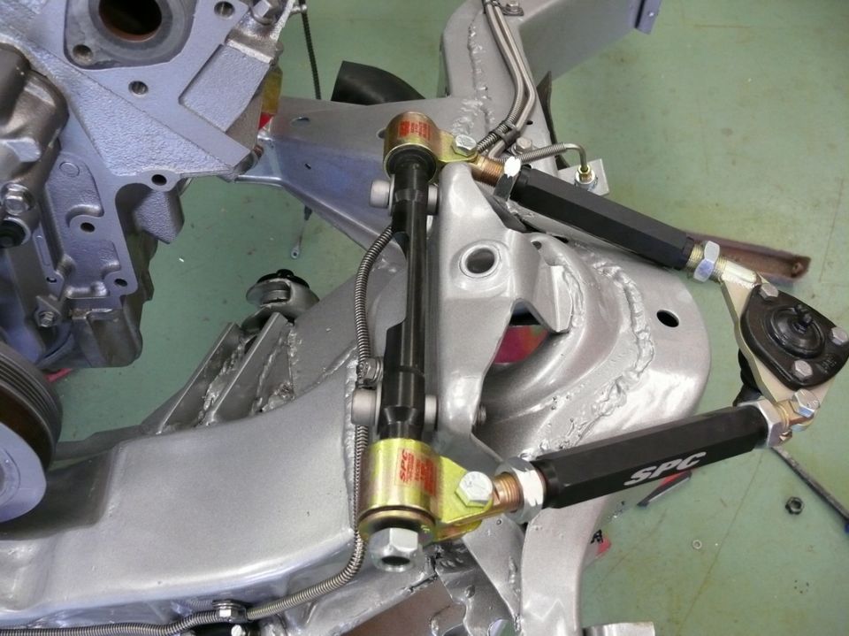 Close-up of SPC adjustable control arms and suspension components on a car frame