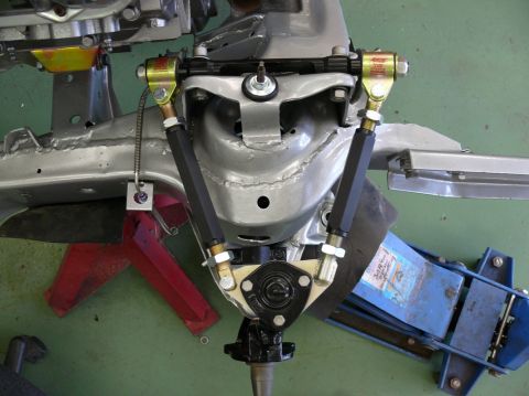 Car suspension components on red jack stands and blue hydraulic jack