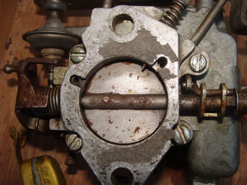 Close-up of a rusty carburetor with a float visible