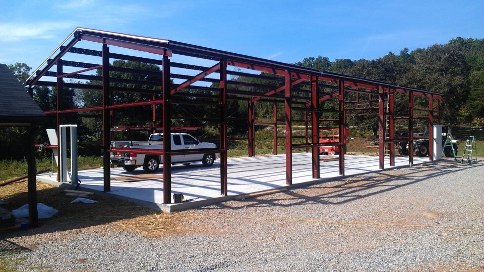 White pickup truck and other vehicles inside a metal building frame