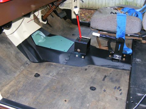 Vehicle interior floor with rubber matting, shifter assembly, and seatbelt
