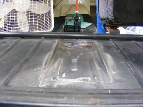 Black metal panel with visible welds and a rectangular cutout, interior view