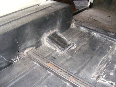 Interior floor pan with welded repairs and a metal grate