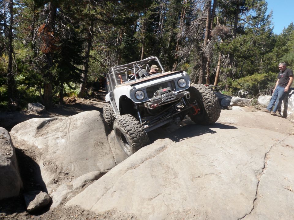 White 1961 International Scout 800 off-roading over large rocks