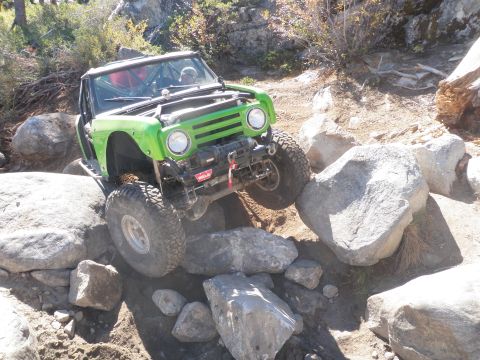 1961 International Scout 800 - This modified off-road vehicle navigates a challenging rocky obstacle course.
