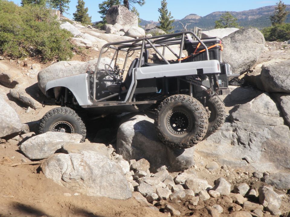 Gray off-road vehicle with roll cage on rocky terrain