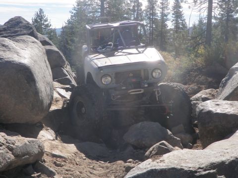 1961 International Scout 800 - This modified International Scout 800 tackles a challenging rocky trail, demonstrating its off-road capabilities.
