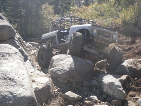 1961 International Scout 800 - Modified 1961 International Scout 800 navigates a rocky trail with its front tire high on a boulder.