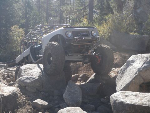 1961 International Scout 800 - Modified 1961 International Scout 800 navigating a rocky trail with its roll cage clearly visible.