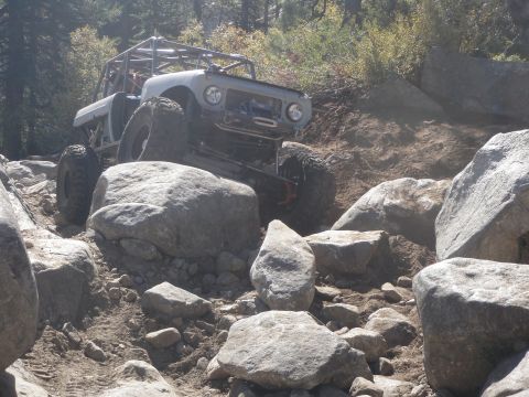 1961 International Scout 800 - This heavily modified vehicle is tackling a challenging rocky obstacle course.
