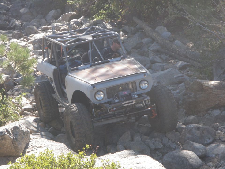 1961 International Scout 800 off-roading on a rocky trail, front-mounted winch, roll cage