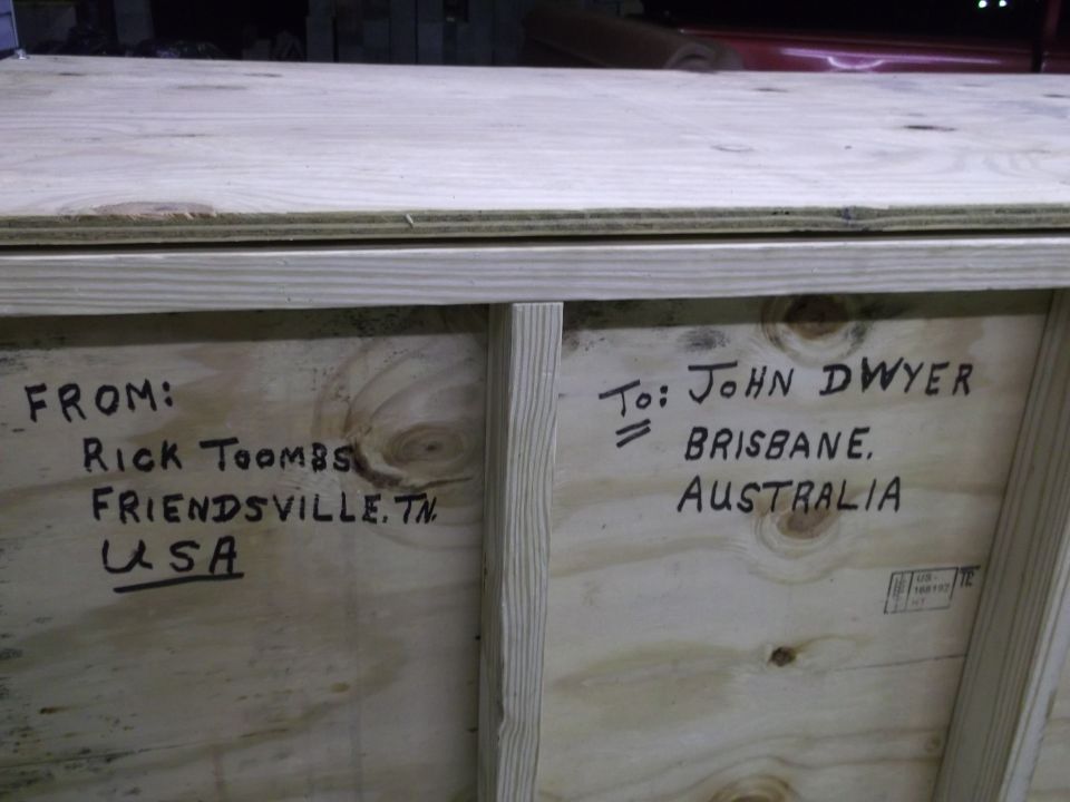 Wooden crate with handwritten shipping labels: FROM: Rick Toombs, Friendsville, TN, USA and TO: John Dwyer, Brisbane, Australia