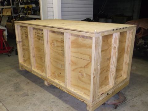 1970 Ford Mustang - A large wooden crate is the primary subject, with some handwritten text visible on its side.