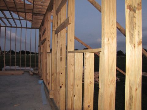 1995 Ford Bronco - The image shows the framing of a building under construction, with wooden studs and beams against a dusky sky.