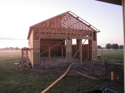 1995 Ford Bronco - The skeletal structure of a house is visible, with exposed wooden framing and unfinished walls.