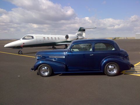 1939 Chevrolet Biscayne - A blue 1939 Chevrolet sedan is parked on an airport tarmac next to a private jet.