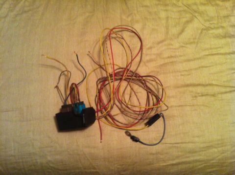 1982 Ford Bronco - A tangled wiring harness with a black connector block is spread out on a fabric surface.