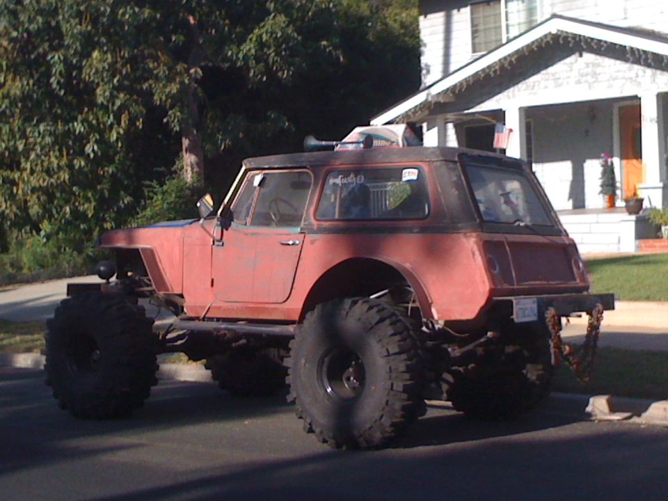 Red off-road vehicle with large tires and a hardtop