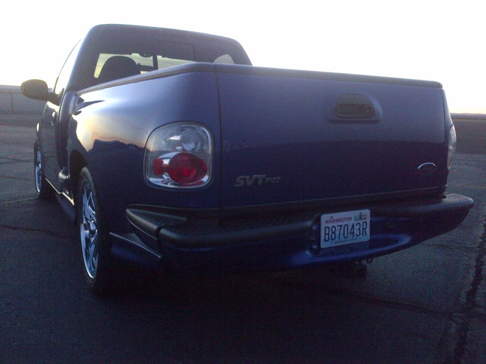Rear view of blue SVT pickup truck with custom wheels and license plate B87043R