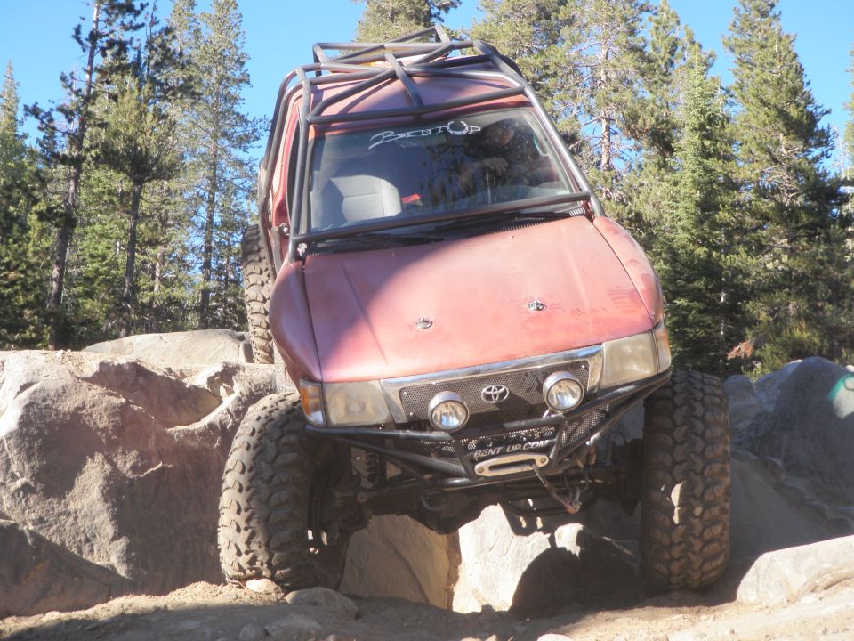 red Toyota 4Runner on rocks, custom roll cage, winch on front bumper