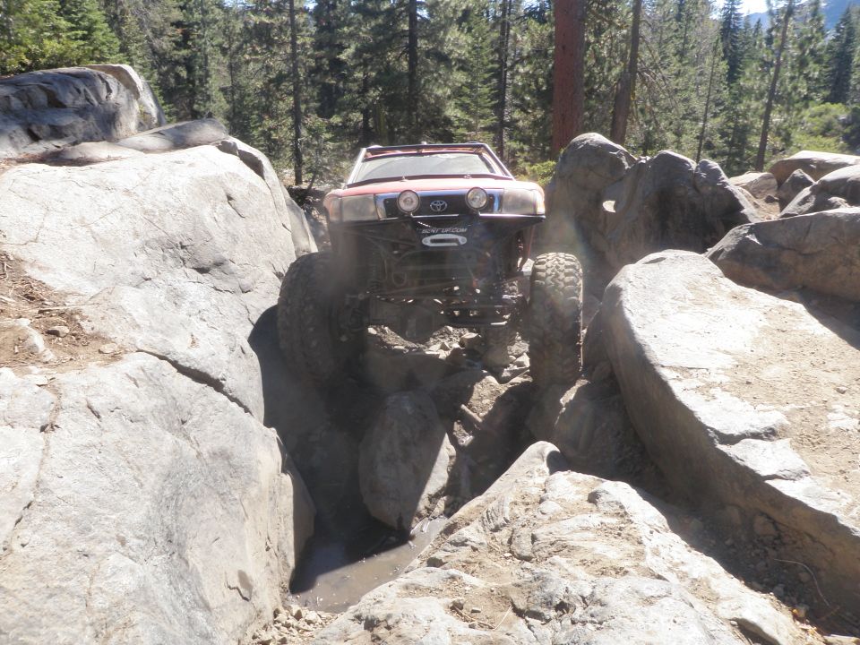 Red off-road vehicle with winch on rocky trail