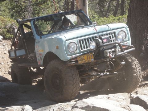 1961 International Scout 800 - This modified International Scout is navigating a challenging off-road course with large tires and a lifted suspension.