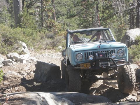 1961 International Scout 800 - A light blue 1961 International Scout 800 navigates a challenging rocky terrain on an off-road trail.