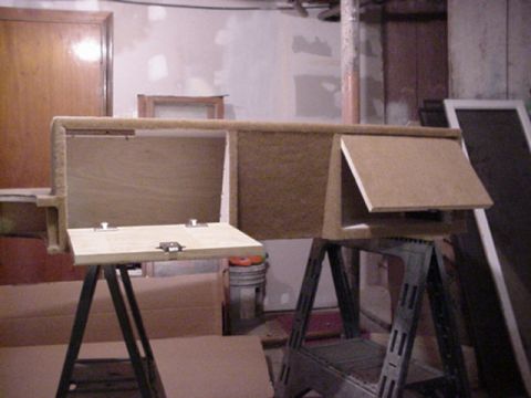 1993 Ford Bronco - A workshop scene showing wooden and particleboard panels or a partially assembled box structure resting on two black metal folding sawtable…
