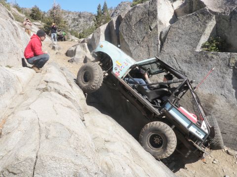 1961 International Scout 800 - A heavily modified off-road vehicle attempts to climb a challenging rocky terrain.