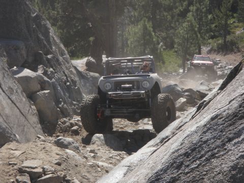 1961 International Scout 800 - Two off-road vehicles tackle a challenging rocky trail in a mountainous area.