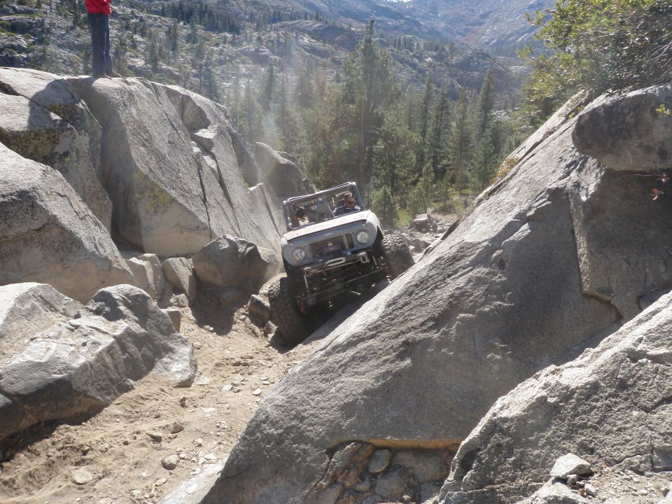Off-road vehicle climbing rocks on a mountain trail