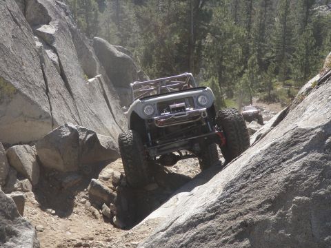 1961 International Scout 800 - Modified 1961 International Scout 800 navigates a steep, rocky incline on an off-road trail.
