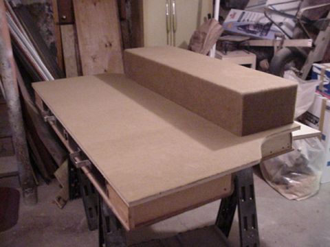 1993 Ford Bronco - Custom fabricated cargo-area console or storage box under construction on sawhorses in a basement workshop, built from particle board with…