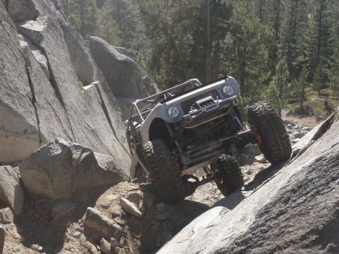 1961 International Scout 800 - This heavily modified off-road vehicle navigates a challenging rocky incline.