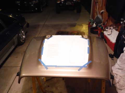 2005 Jeep Wrangler - A car hood is prepped with a paper template, with other vehicles in the background.