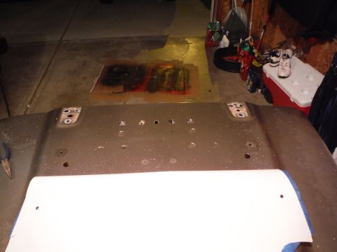 2005 Jeep Wrangler - A vehicle hood is shown with mounting holes, possibly undergoing maintenance or modification.