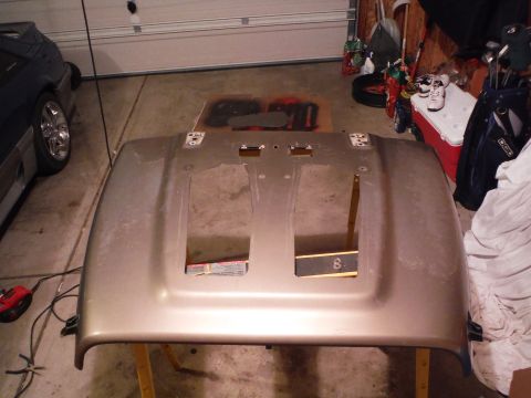 2005 Jeep Wrangler - A gold Jeep Wrangler hood is shown disassembled in a garage setting.