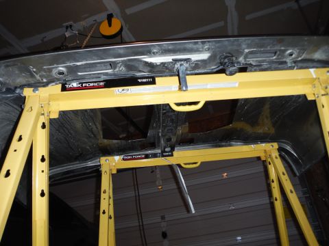 2005 Jeep Wrangler - Underside of a car hood is held up by yellow stands, revealing its internal structure and labels.