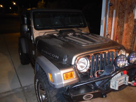 2005 Jeep Wrangler - A Jeep Wrangler Rubicon is parked in a garage, showing its front end with custom modifications.