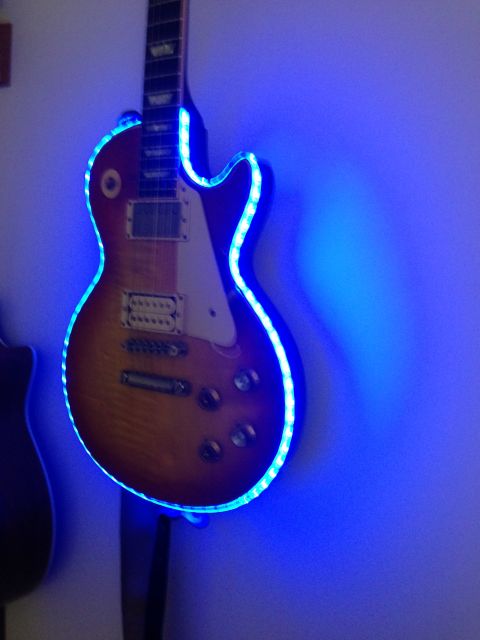 1989 Mazda MX-6 - An electric guitar with blue LED lights is mounted on a wall.