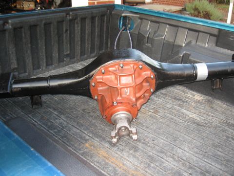 1994 Ford Bronco - A rear differential assembly is shown, an orange center section with a visible 'N' marking and black axle tubes.